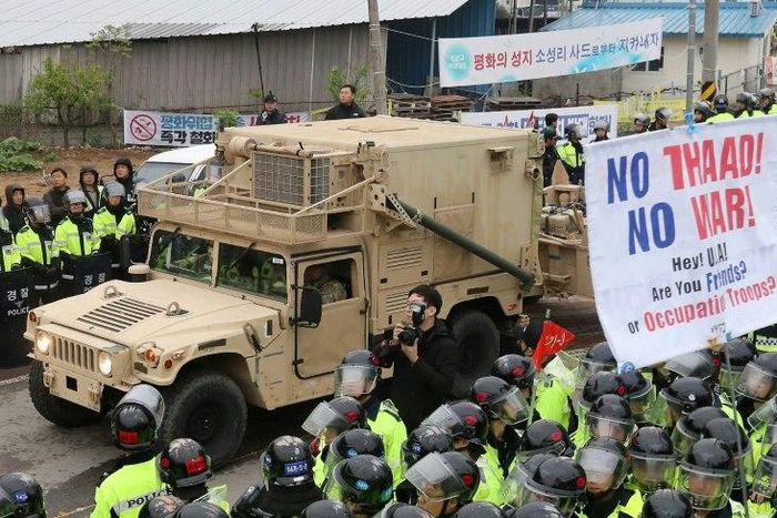 Protesters and police stand by as trailers carrying US THAAD missile defence equipment enter a deployment site in Seongju, on April 26, 2017