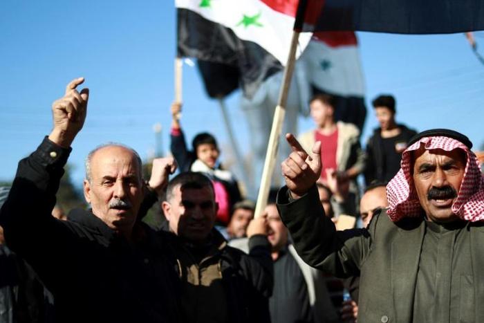 Syrian demonstrators protest in the northeastern Syrian Kurdish-majority city of Qamishli, asking for the Syrian army's protection as Turkey threatens to carry out a fresh offensive that began even before the US decision to withdraw their troops