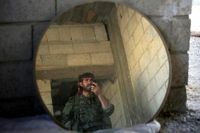 A fighter of the US-backed Syrian Democratic Forces speaks on a walkie talkie during their advance into the Islamic State group stronghold of Raqa on June 21, 2017