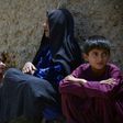 An internally-displaced Afghan woman and children who left their homes following a mass-kidnapping by suspected militants look on after arriving from the district of Shawali Kowt following in Kandahar on July 23, 2017