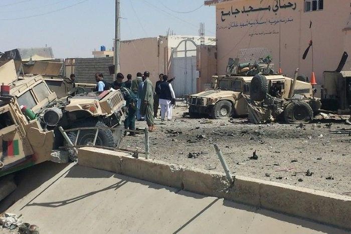 Afghan security personnel inspect the site of a suicide attack near the main police headquarters in Lashkar Gah, capital of Helmand province