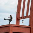 Brazilian superstar and world's most expensive footballer Neymar shoots a ball from the monumental wood sculpture "Broken Chair" during an event by the (NGO) Handicap International on August 15, 2017 at the Place des Nations in Geneva