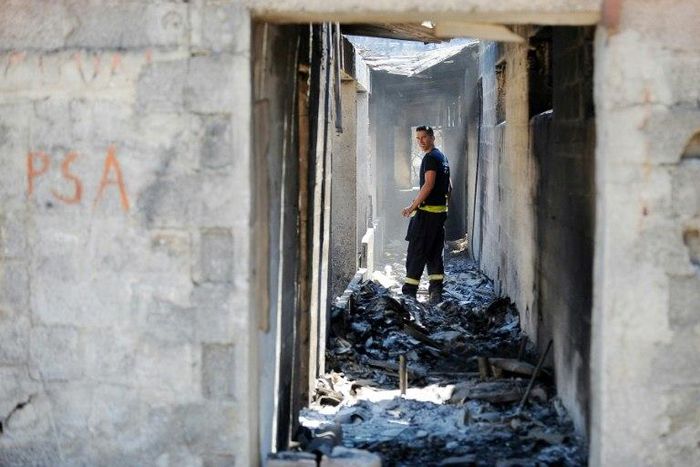A firefighter walks in a burnt-out house in the village of Zrnovnica, near the Adriatic coastal town of Split in July 2017