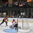 Malaysia's Jun Ming Low (C) dribbles the puck past Indonesia's goalkeeper Sangga Munggaran Putra (R) during their ice hockey match at the 29th Southeast Asian Games (SEA Games) in Kuala Lumpur on August 20, 2017