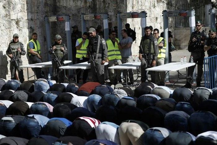Palestinian Muslim worshippers refuse to enter the Al-Aqsa mosque compound after Israeli set up metal detectors and cameras as part of new security measures