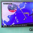 A South Korean soldier walks past a television screen showing a graphic of the distance between North Korea and Guam at a railway station in Seoul
