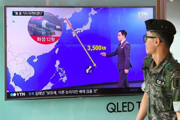 A South Korean soldier walks past a television screen showing a graphic of the distance between North Korea and Guam at a railway station in Seoul