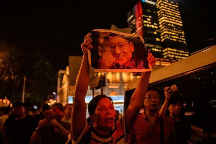 An activist holds a poster of terminally-ill Nobel laureate Liu Xiaobo on the sidelines of a vigil for him in Hong Kong on June 29, 2017.Liu wants Chinese authorities to let him get treatment abroad, friends say, as officials said his cancer has spread...