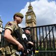 A British soldier and armed policeman patrol near the Houses of Parliament in central London