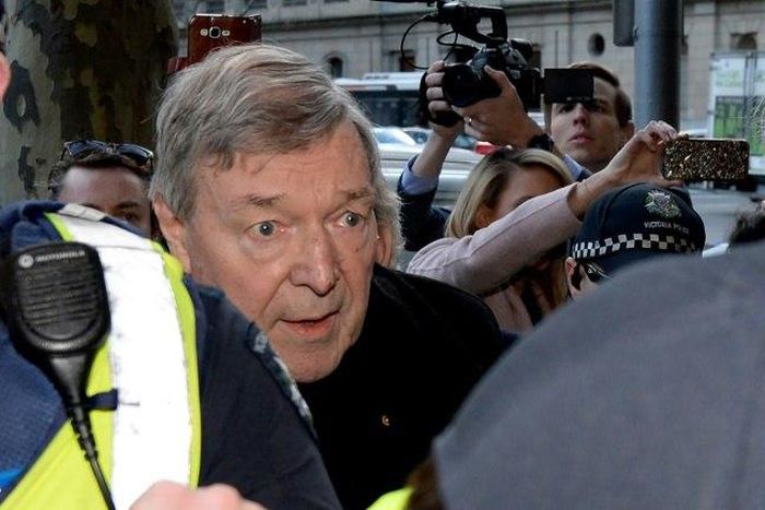 Cardinal George Pell arrives under heavy police protection for his first court hearing over historical sexual abuse allegations