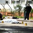 A gang shooting at a Guatemalan hospital leaves seven dead, including a prison guard (front) and a civilian caught in the crossfire, seen here covered as forensic workers examine the scene