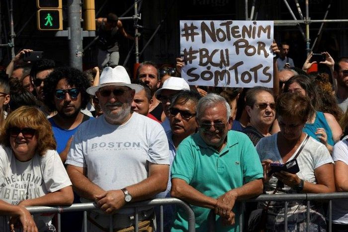 Somebody holds up a sign reading "We are not afraid. Barcelona, we are all" before a crowd observes a minute of silence for the victims of the Barcelona attack at Plaza de Catalunya on August 18, 2017