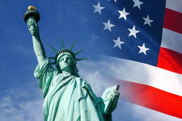 Statue of Liberty and United States flag waving in wind