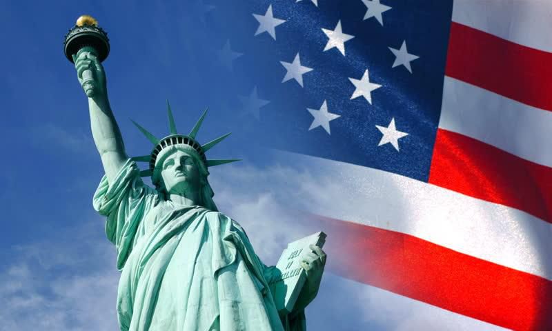 Statue of Liberty and United States flag waving in wind