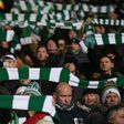 Celtic fans hold up team scarves in Glasgow