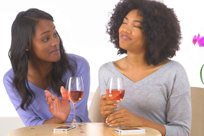 Friends having a chat over a bottle of wine [Credit: Video Blocks]