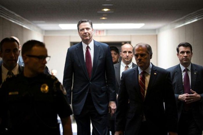 Former FBI director James Comey, center, leaving a closed hearing of the Senate Intelligence Committee on Thursday