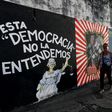 People walk past murals protesting the state of the economy in San Juan, Puerto Rico, as the former Spanish colony of 3.5 million, now a US territory, struggles under a mountain of debt