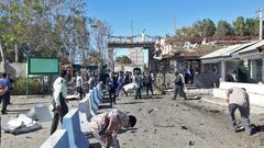 Iranian police survey the aftermath of a suicide car bombing which killed at least two people and wounded many more outside police headquarters in the southeastern port city of Chabahar