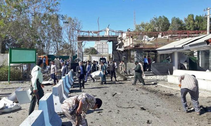 Iranian police survey the aftermath of a suicide car bombing which killed at least two people and wounded many more outside police headquarters in the southeastern port city of Chabahar