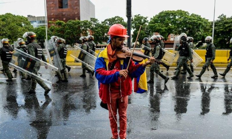 Venezuelan opposition demonstrator Wuilly Arteaga, shown here playing his violin during a May protest against President Nicolas Maduro in Caracas, has been banned from rallies after nearly three weeks in prison Arteaga, 23, was freed overnight on Augus...