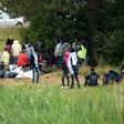 This photo taken on July 03, 2017 shows migrants waiting in a field near the port of Calais, northern France