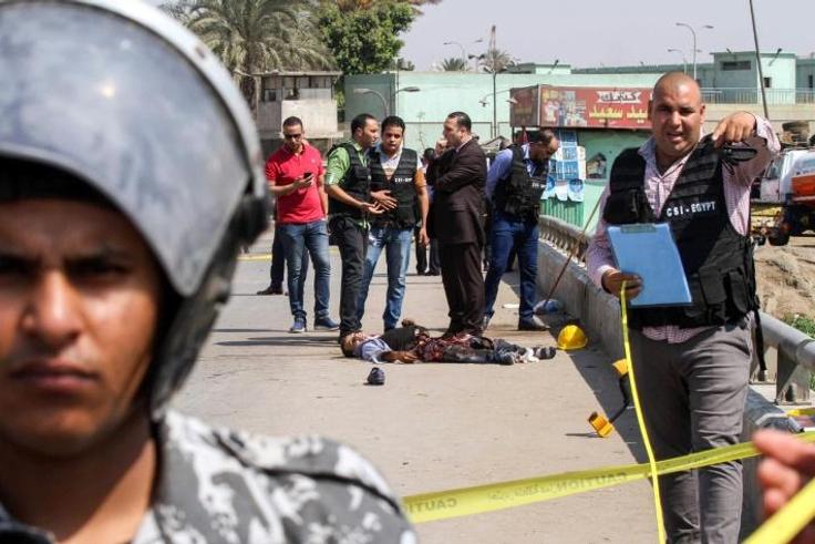 Egyptian investigators gather around the body of a suicide bomber who blew himself up near a Coptic Orthodox church on the edge of Cairo on August 11, 2018