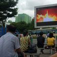 People watch as coverage of an ICBM missile test is displayed on a screen in a public square in Pyongyang on July 29, 2017
