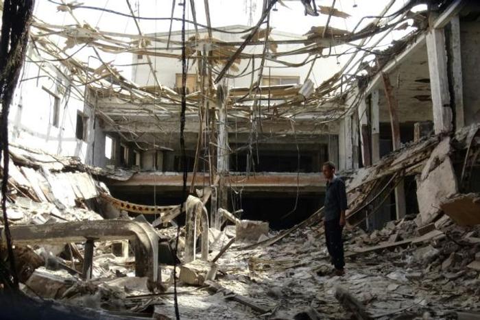 A man inspects the ruins of a factory hit by fierce fighting for the Yemeni port city of Hodeida that a UN-brokered truce which went into effect on Tuesday is intended to halt