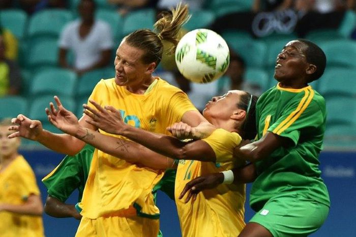 Emily Van Egmond (L) and Kyah Simon of Australia fight for the ball with Zimbabwe's Lynett Mutokuto during their Rio 2016 Olympic Games women's football match, in Salvador