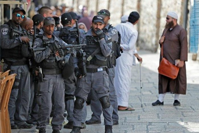 Israeli security forces stand by as Palestinian worshippers gather to pray in the old city of Jerusalem on July 26, 2017