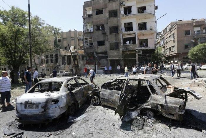 Charred vehicles are seen on the site of a suicide bomb attack in the Syrian capital's eastern Tahrir Square district, on July 2, 2017