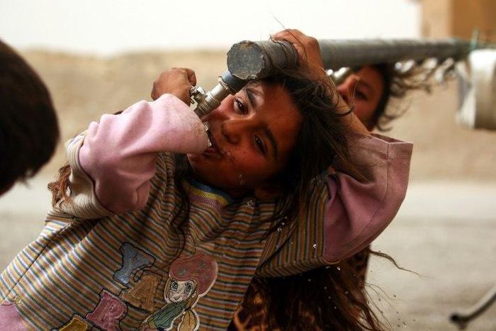 Children who have fled the Islamic State group bastion of Raqa drink from water taps at a camp for the displaced around 25 kilometres (15 miles) from the city on May 10, 2017