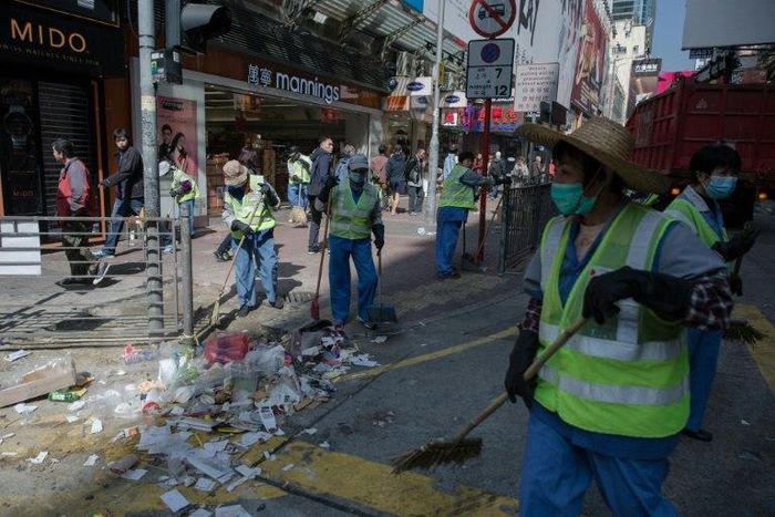 Workers clear debris on a street following the Mongkok riots of February 2016