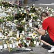 People bring candles and flowers to a makeshift memorial for the victims of the stabbings in the Finnish city of Turku