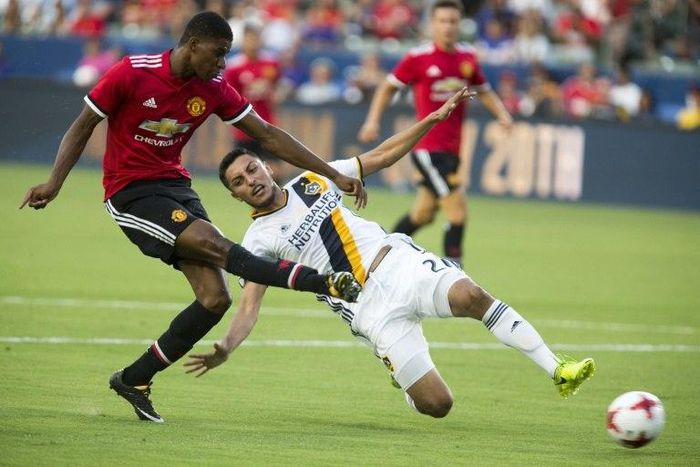 Manchester United's Marcus Rashford kicks the ball past Hugo Arellano of Los Angeles Galaxy during a friendly match in Carson, California