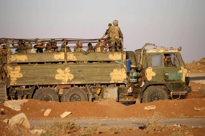 Syrian government soldiers ride in a truck near a border crossing with Jordan on July 6, 2018, after they reseized it from rebel forces