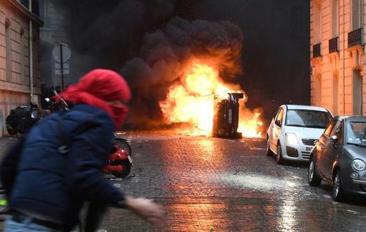 A car burns on Paris's famous Champs-Elysees avenue as the French capital is hit by another round of "yellow vest" protests on Saturday