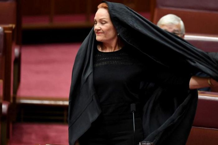 Australian One Nation party leader, Senator Pauline Hanson pulls off a burqa in the Senate chamber at Parliament House in Canberra, Australia, August 17, 2017.