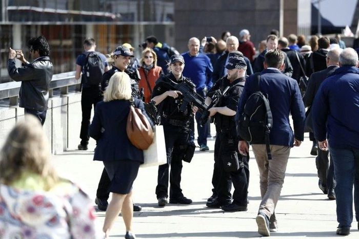 Armed woman police officers patrol with their male colleagues on London Bridge in London