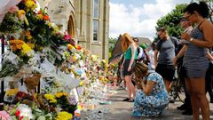 People look at floral tributes for victims of the Grenfell Tower block fire that have been left outside the Notting Hill Methodist Church in west London, on June 17, 2017