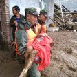 Rescuers carry a survivor of the landslide at Puge