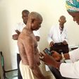 A doctor takes pictures of a man's skin condition for diagnosis through an online dermatology platform in Mali