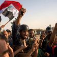 Members of Iraq's federal police force wave Iraq's national flag as they celebrate in the Old City of Mosul on July 9, 2017 after recapturing the city