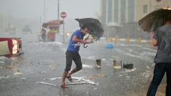 A man holds an umrella during a heavy downpour of hail at Taksim in Istanbul on July 27, 2017