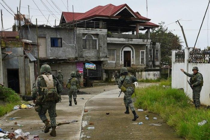 Philippine Marines taking cover from sniper fire while on patrol at the frontline in Marawi on the southern island of Mindanao