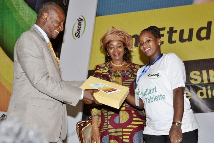 Guinean President Alpha Conde (L) presents a student with a tablet computer in October 2015 but his campaign promise of 'one student' one tablet' has yet to materialise