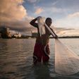 A fisherman works off a beach at Tumon Bay in Guam