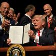 US President Donald Trump holds up a memorandum tightening restrictions on trade and travel to Cuba