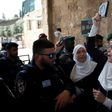 A Palestinian protester holds a copy of the Koran and shouts slogans in front of Israeli security forces during a demonstration in Jerusalem's Old City on July 20, 2017